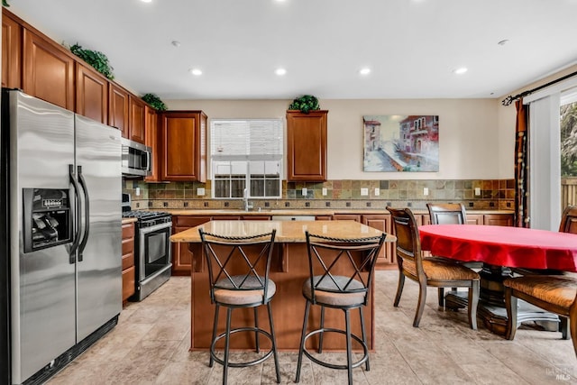 59 Toscana Dr, American Canyon, CA 94503 - kitchen featuring stainless steel appliances, a center island, backsplash, recessed lighting, and a kitchen bar