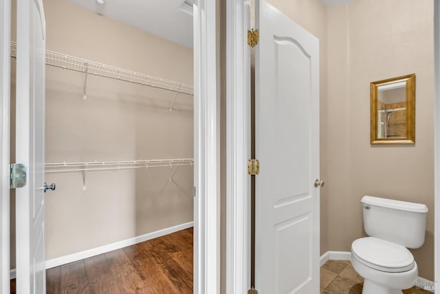 59 Toscana Dr, American Canyon, CA 94503 - bathroom featuring toilet, a spacious closet, baseboards, and wood finished floors