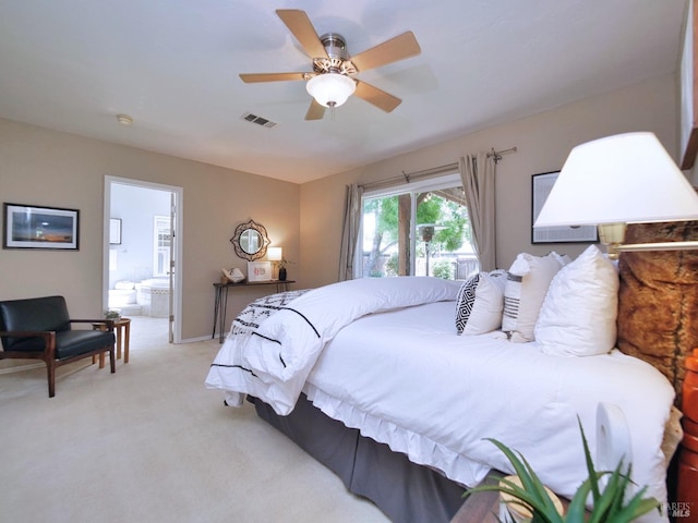 bedroom with light colored carpet, a ceiling fan, and connected bathroom