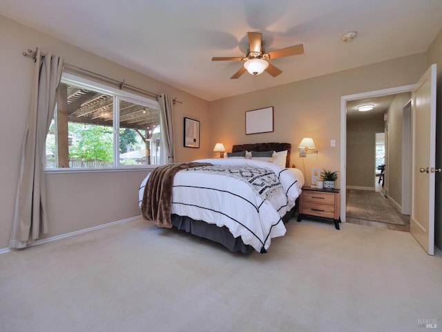 bedroom featuring light carpet, baseboards, and a ceiling fan