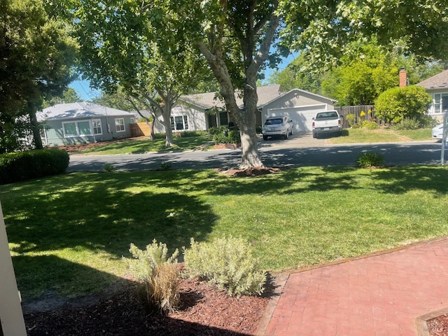 view of yard with asphalt driveway