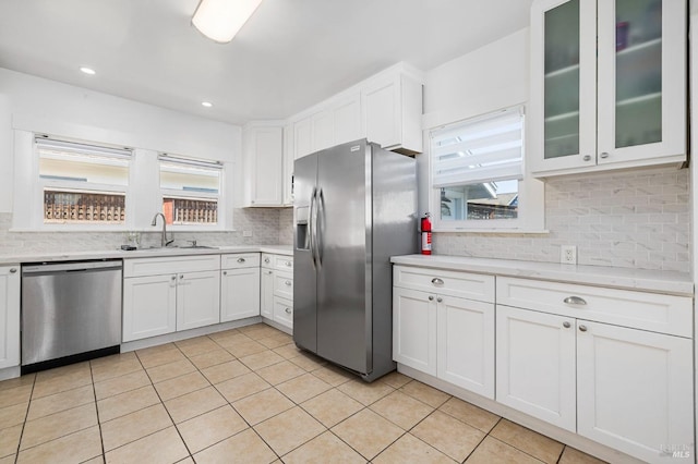 kitchen with a sink, light countertops, white cabinets, and stainless steel appliances