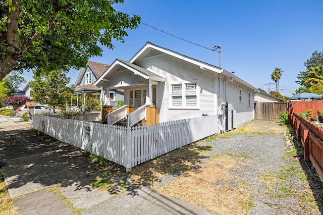 bungalow-style home featuring a porch and a fenced front yard