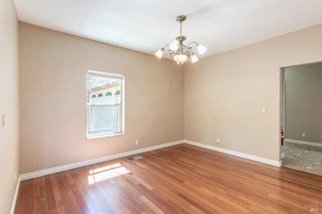 35600 Rock Creek Rd, Shingletown, CA 96088 - empty room with light wood-style floors, baseboards, a chandelier, and visible vents