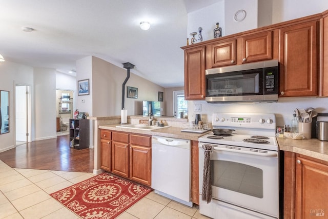 35600 Rock Creek Rd, Shingletown, CA 96088 - kitchen with a sink, light tile patterned floors, a peninsula, lofted ceiling, and white appliances