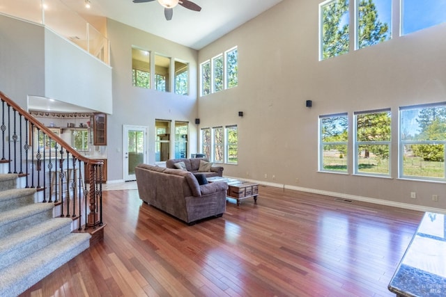 35600 Rock Creek Rd, Shingletown, CA 96088 - living room with ceiling fan, a high ceiling, stairs, baseboards, and hardwood / wood-style flooring