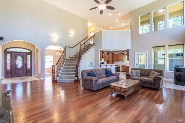 35600 Rock Creek Rd, Shingletown, CA 96088 - living area with a towering ceiling, stairway, arched walkways, hardwood / wood-style flooring, and a ceiling fan