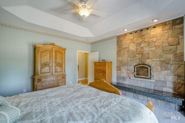 35600 Rock Creek Rd, Shingletown, CA 96088 - bedroom with recessed lighting, a glass covered fireplace, a tray ceiling, and ceiling fan