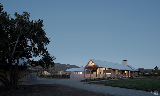 exterior space with fence, a chimney, and a front yard