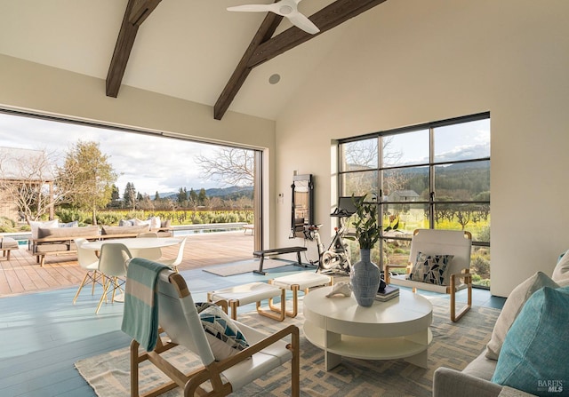 interior space with high vaulted ceiling, ceiling fan, beam ceiling, and wood finished floors