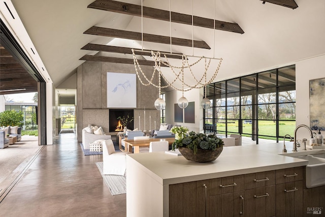 interior space featuring dark brown cabinets, beamed ceiling, a sink, and high vaulted ceiling
