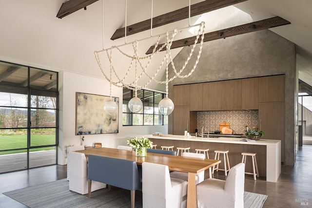 dining room with high vaulted ceiling, beamed ceiling, and concrete flooring