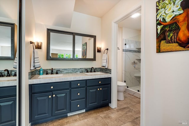 full bathroom featuring a sink, a shower stall, toilet, and double vanity