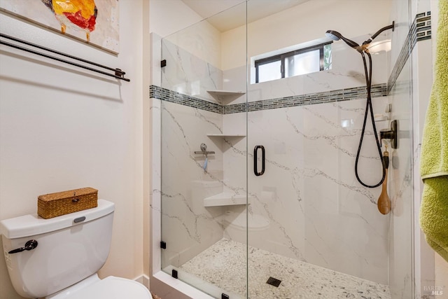 full bath featuring toilet and a marble finish shower