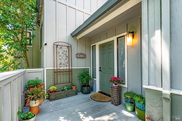 view of exterior entry with covered porch and board and batten siding