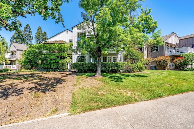view of property hidden behind natural elements with a front lawn