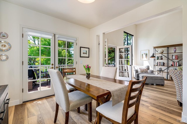dining area with french doors and light wood-type flooring