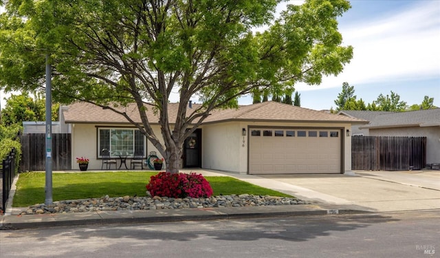 ranch-style house featuring an attached garage, stucco siding, fence, concrete driveway, and a front lawn