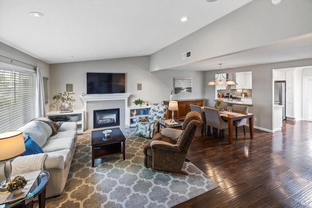 living room featuring vaulted ceiling, dark wood-style flooring, visible vents, and recessed lighting