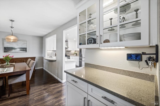 kitchen featuring dark wood finished floors, glass insert cabinets, and white cabinetry