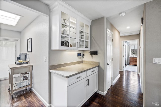 bar with plenty of natural light, baseboards, a skylight, and dark wood-style floors