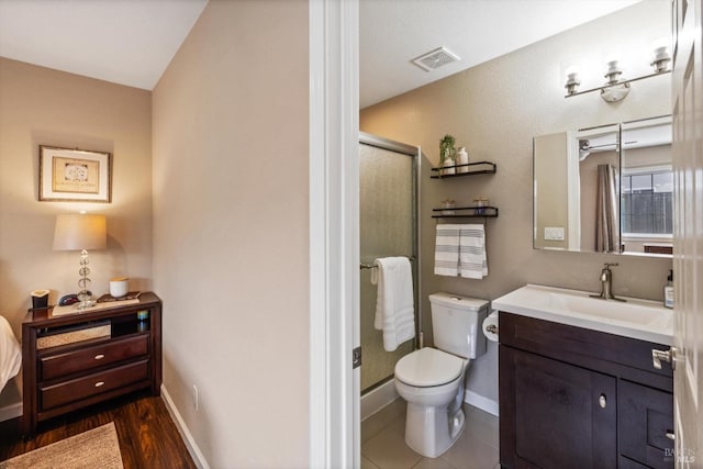bathroom featuring toilet, baseboards, visible vents, a shower stall, and vanity