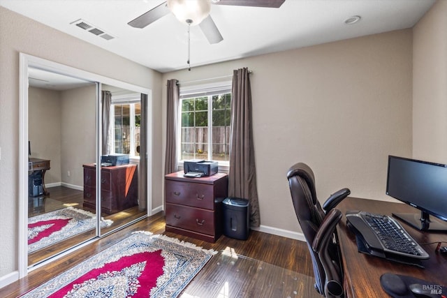 office area featuring a ceiling fan, baseboards, visible vents, and dark wood-type flooring