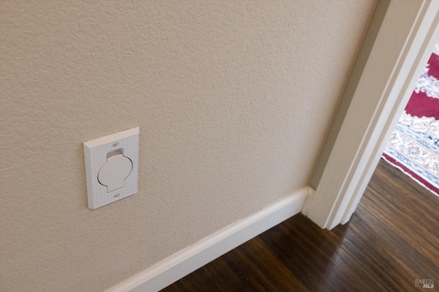 room details with a textured wall, baseboards, and wood finished floors