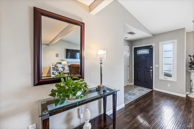 entrance foyer featuring wood finished floors, vaulted ceiling, baseboards, and visible vents