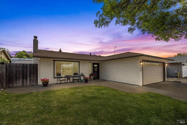 single story home with a garage, stucco siding, a chimney, fence, and a front lawn
