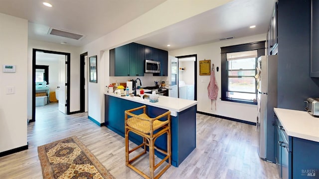3314 Gravenstein Hwy S, Sebastopol, CA 95472 - kitchen with washing machine and clothes dryer, stainless steel appliances, a sink, light countertops, and light wood-type flooring