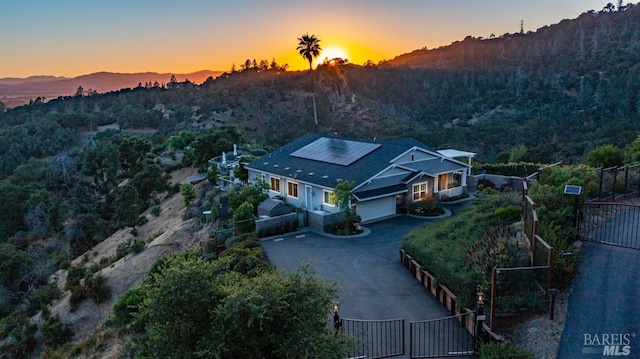 aerial view at dusk with a view of trees and a mountain view