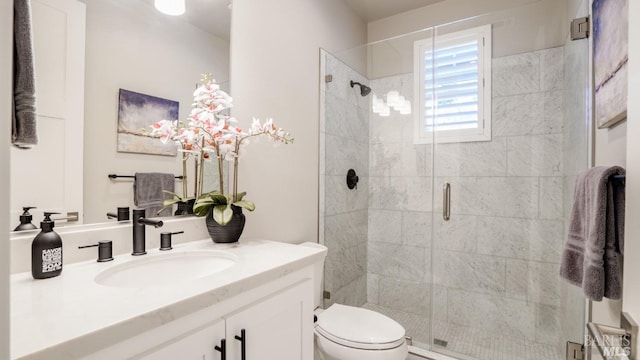 full bath featuring toilet, a shower stall, and vanity