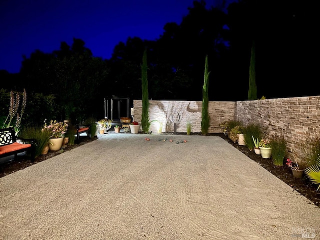 patio at twilight featuring fence
