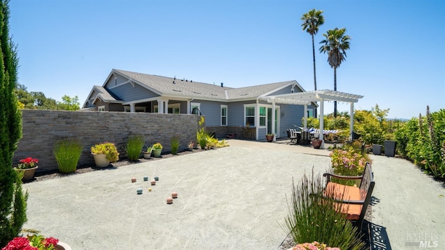 rear view of property with fence, a pergola, and a patio area
