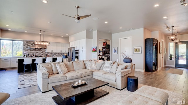 living room featuring recessed lighting, a healthy amount of sunlight, and light wood-style flooring