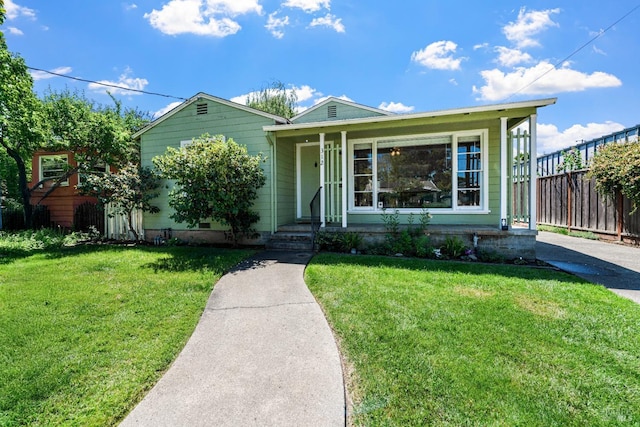 view of front of home featuring fence and a front lawn