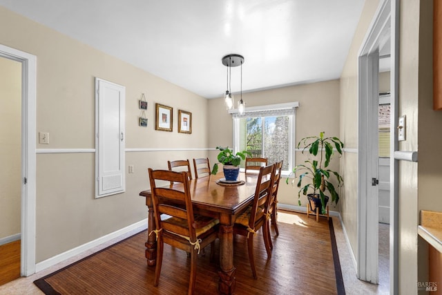 dining area with baseboards and wood finished floors