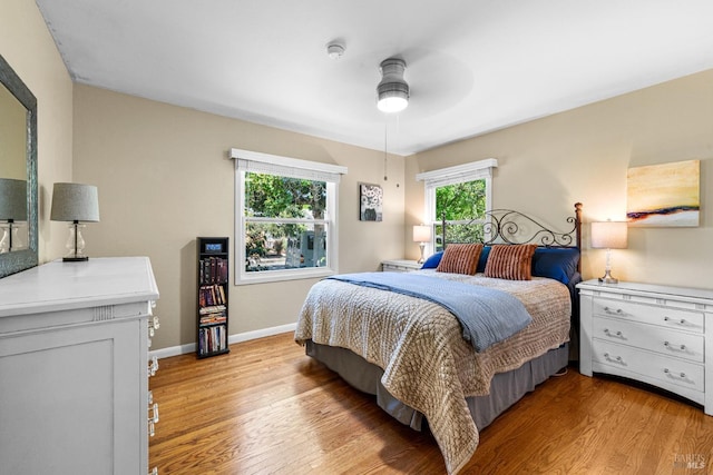 bedroom with light wood-type flooring, baseboards, and ceiling fan