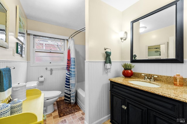 bathroom featuring toilet, wainscoting, shower / tub combo with curtain, and vanity