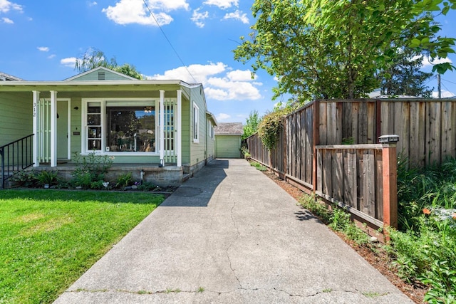 exterior space with a lawn, driveway, fence, and covered porch