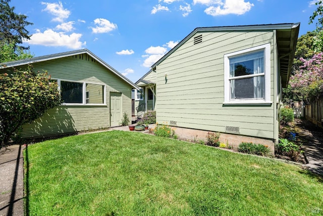 view of side of property featuring a lawn, crawl space, and fence
