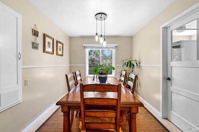 dining space with baseboards and wood finished floors