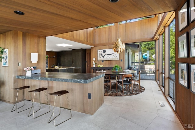1499 Rockville Rd, Fairfield, CA 94534 - kitchen with wood walls, dark countertops, a peninsula, light tile patterned floors, and wood ceiling