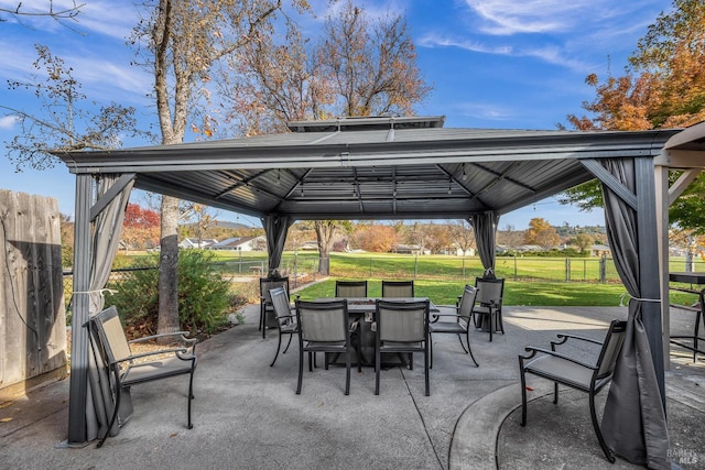 view of patio featuring a gazebo, fence, and outdoor dining area