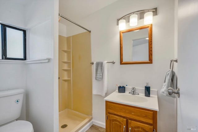 full bath featuring vanity, a stall shower, and toilet