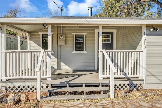 view of exterior entry featuring covered porch