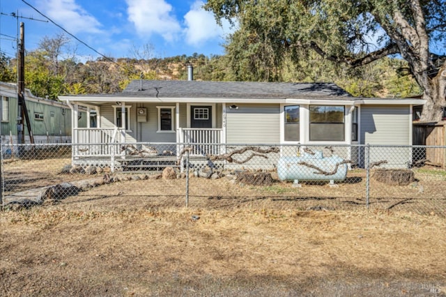 view of front of property with a fenced front yard and a porch