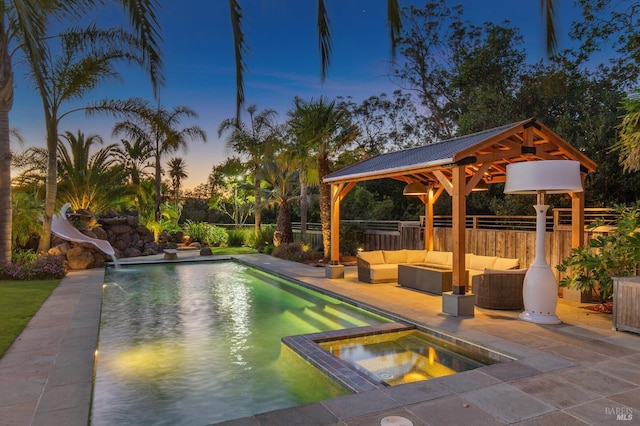220 Deer Park Ave, San Rafael, CA 94901 - pool at dusk with a gazebo, a water slide, outdoor lounge area, fence, and a pool with connected hot tub
