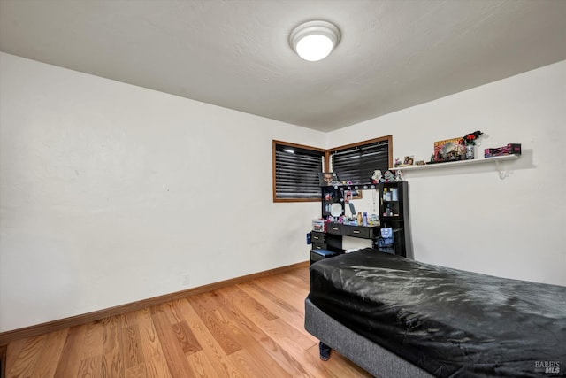 bedroom with baseboards and wood finished floors